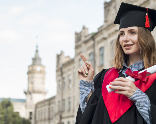 Graduated happy girl posing in front of university