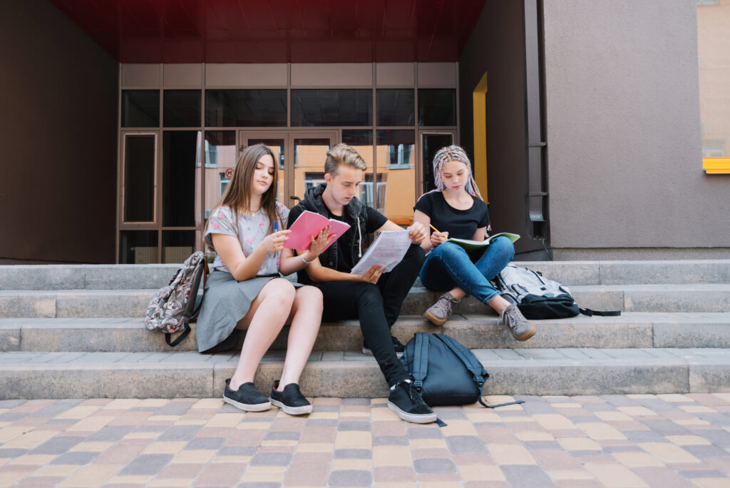Stunts learning sitting on stairs in front of university campus