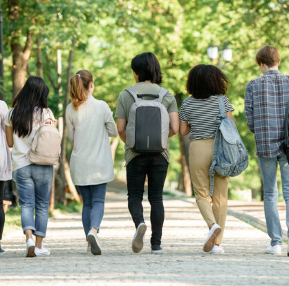 Backside of students walking carrying bags on thier backs