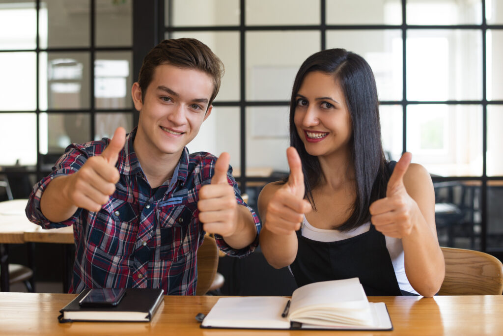 Is a 3.0 GPA good in college? Two intelligent students doing thumbs up