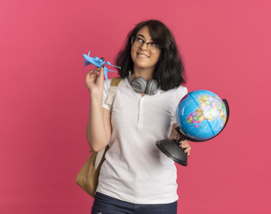 Young student thinking how can I study abroad for free, holding globe in one hand and aeroplane toy in another hand