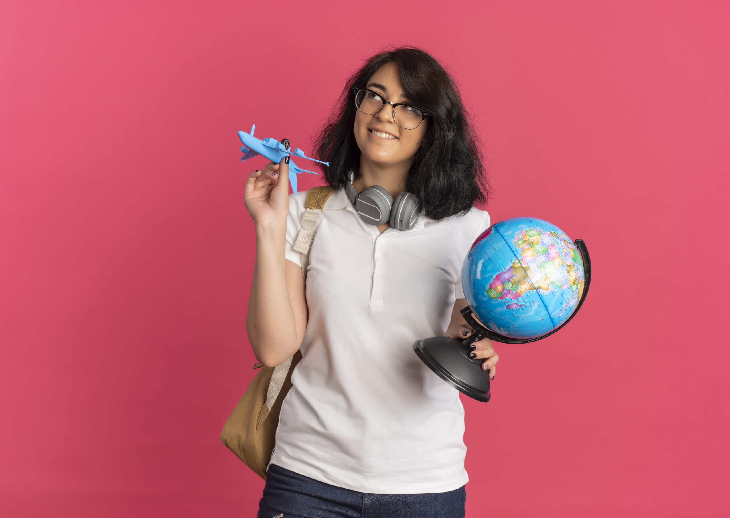 Young student thinking how can I study abroad for free, holding globe in one hand and aeroplane toy in another hand